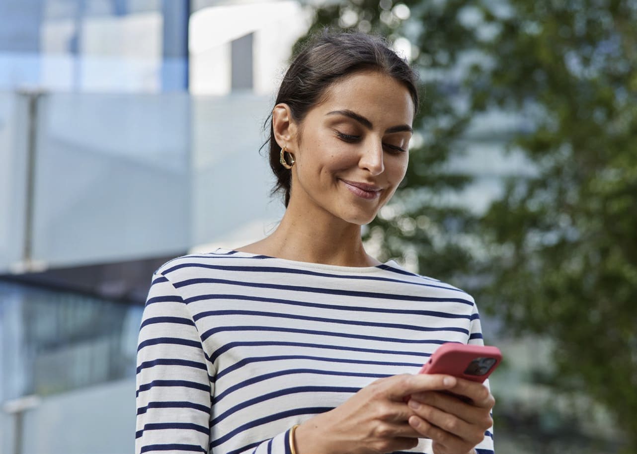 Woman smiling while looking at cell phone